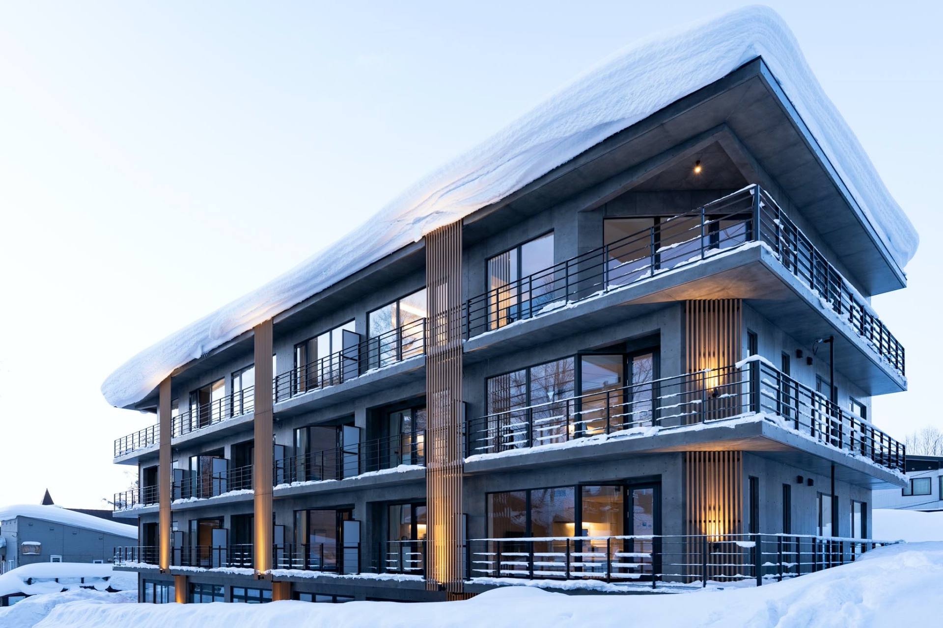 Skier in red jacket enjoys deep powder and panoramic mountain views at one of Japan’s best ski resorts in winter.