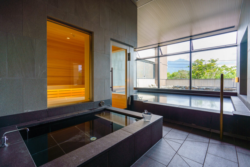 Interior of Yukoro Onsen in Niseko - two indoor baths and a sauna lit in orange light