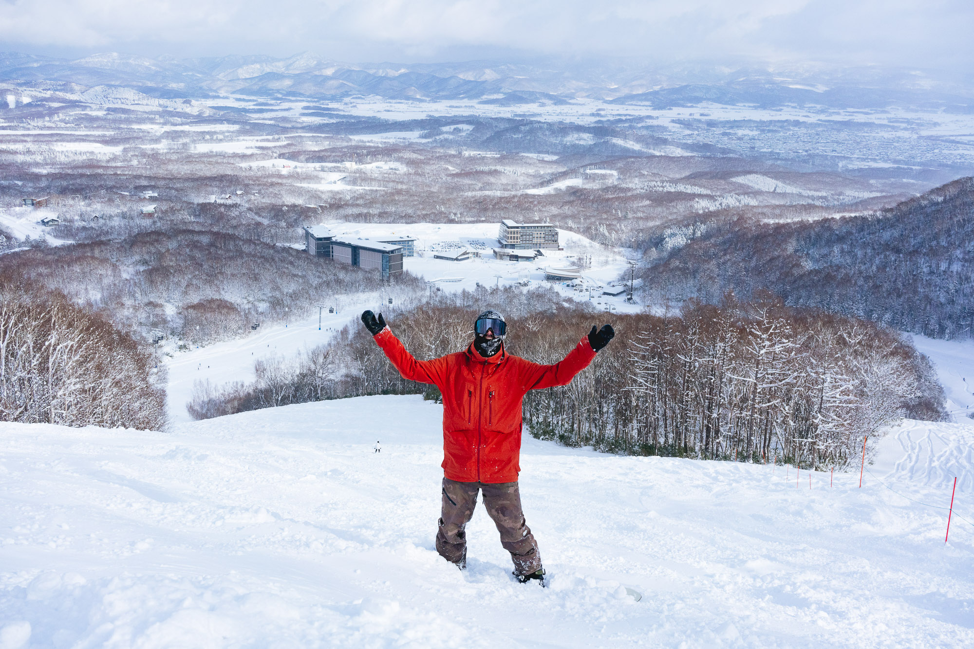 japans-best-ski-resorts-11 Skier in red jacket enjoys deep powder and panoramic mountain views at one of Japan’s best ski resorts in winter.