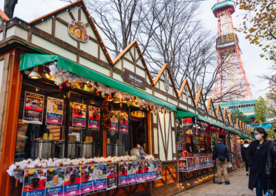 Sapporo Christmas Market festive stalls selling hot drinks and gifts with shoppers walking near the Sapporo TV Tower