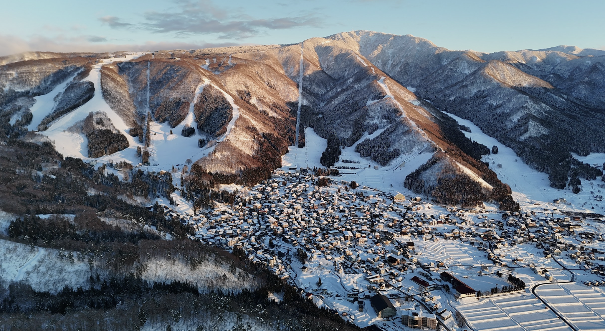 An aerial view of Hirafu village covered in snow and a layer of fog